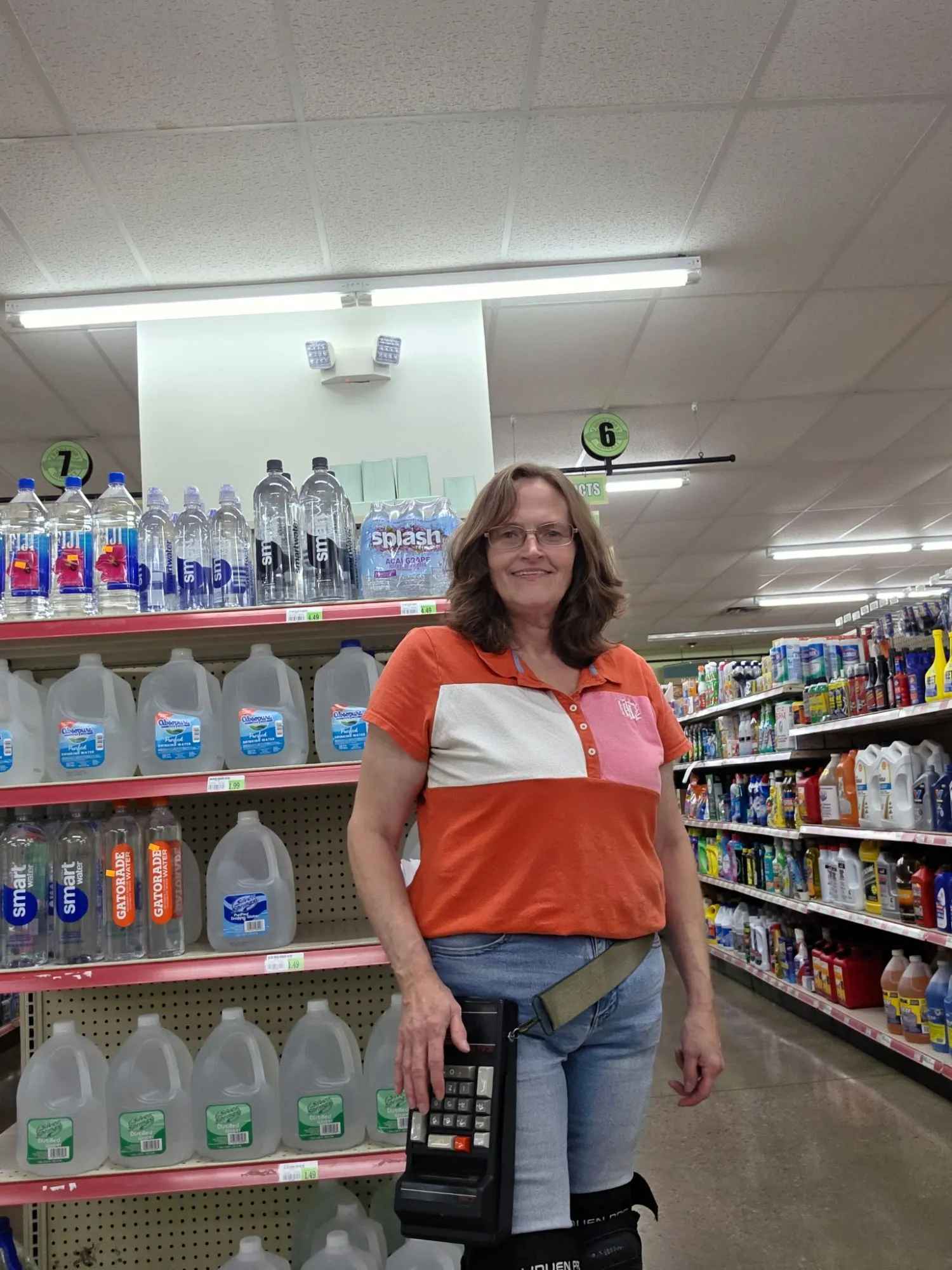 Angie in a store aisle with her handheld counting machine